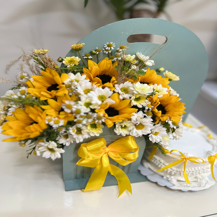 باکس گل سبز آبی با گل های آفتابگردون و بابونه همراه کیک تولد
