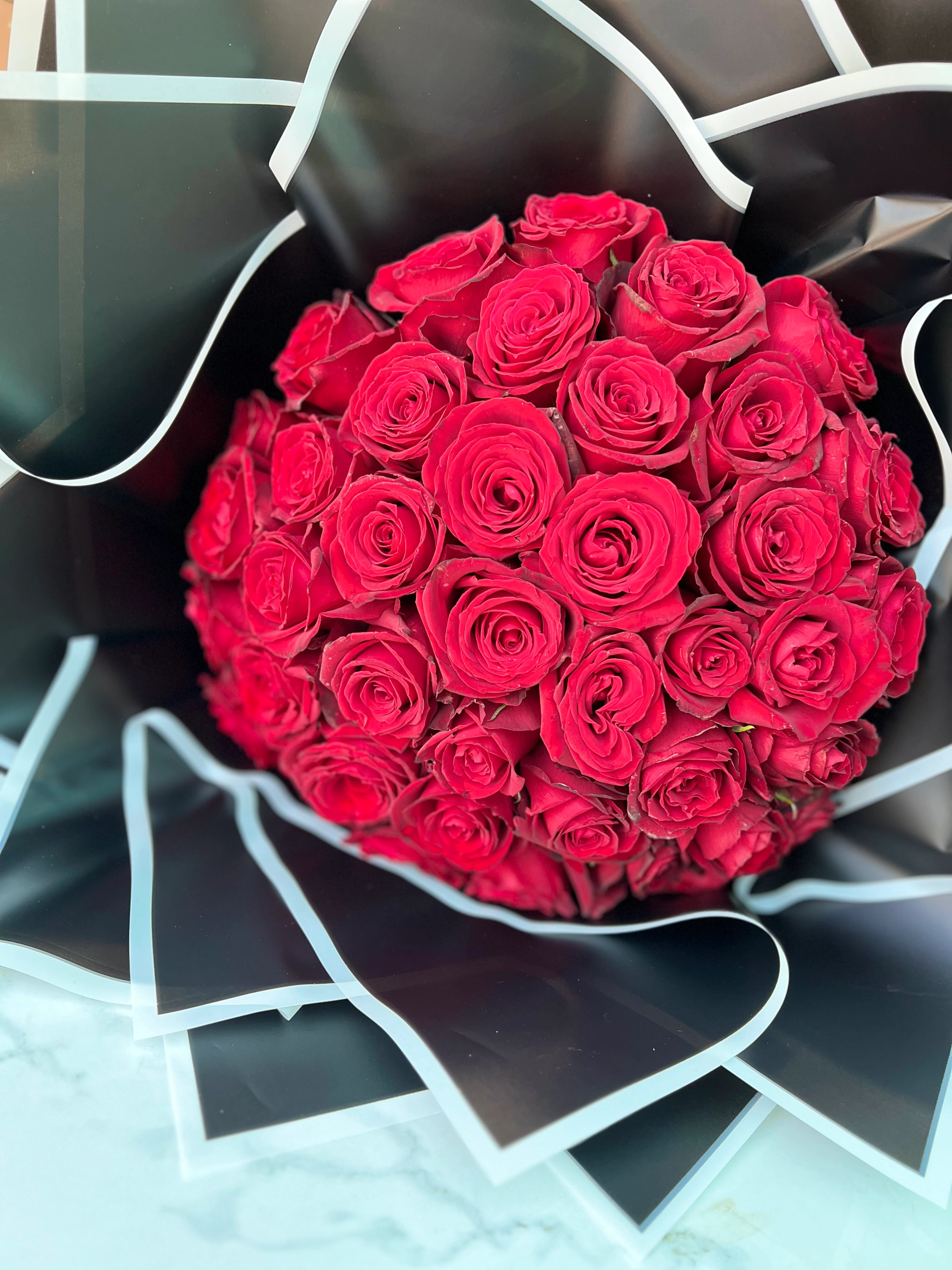 دسته گل 40 شاخه رز قرمز با کاغذ مشکی دور سفید