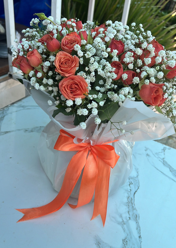 دسته گل نارنجی داخل گلدون شیشه ای