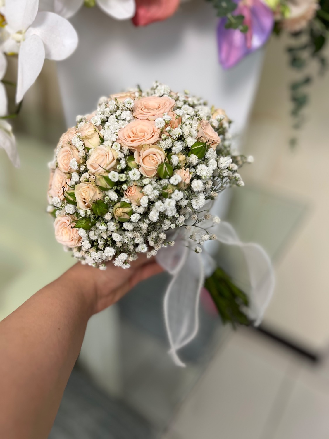دسته گل طبیعی گرد عروس با رزهای مینیاتوری هلویی، ژیپسوفیلا و پاپیون حریر سفید - سام فلاور.