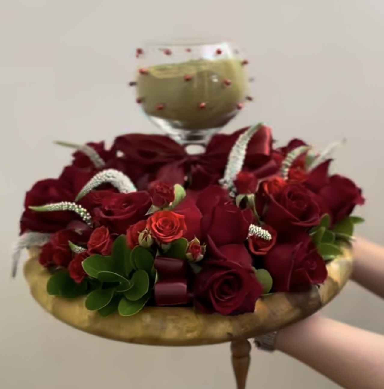 سینی طلایی تزیین شده با رزهای قرمز تیره و مخملی به همراه ظرف حنا در مرکز، طراحی لوکس و کلاسیک برای مراسم حنابندان - برند سام فلاور